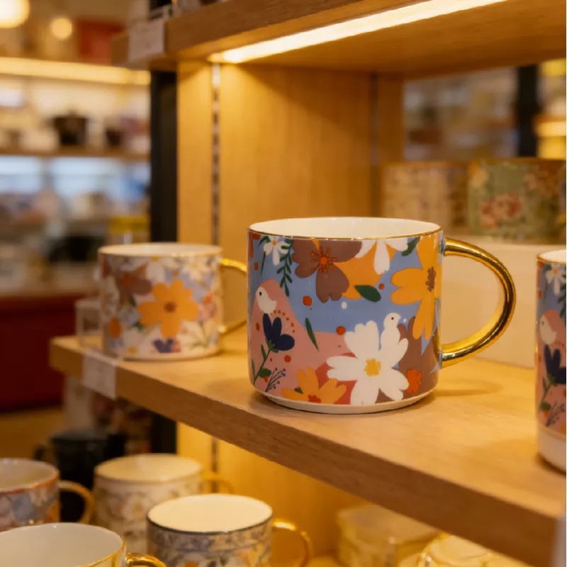 Kubek ceramiczny w żywym kwiatowym kolorze ze złotym wykończeniem Kubek ceramiczny w żywym kwiatowym kolorze ze złotym wykończeniem