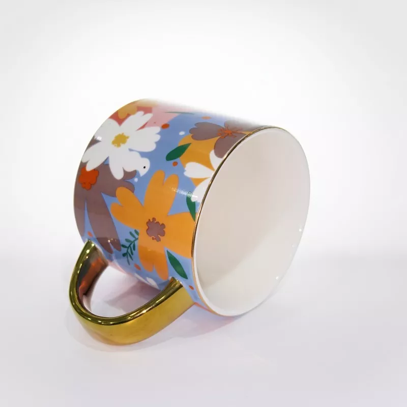 Kubek ceramiczny w żywym kwiatowym kolorze ze złotym wykończeniem